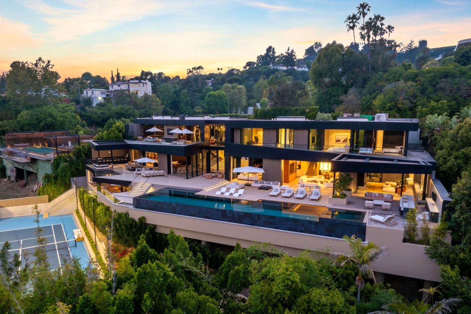 Hillside residence at dusk with pool and terraces
