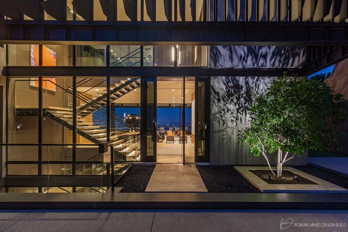 Entry court and front elevation lit at night